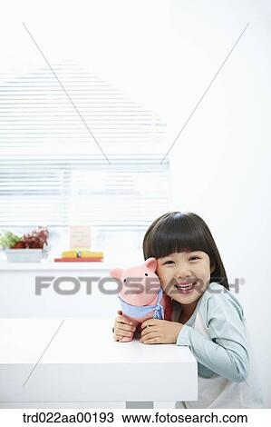 Stock Image - A girl with a pink piggy bank on her face. Fotosearch