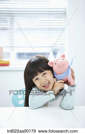 A girl with a pink piggy bank on her face View Large Photo Image Stock Photo - A girl with a pink piggy bank on her face. Fotosearch