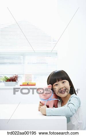 Stock Photography - A girl with a pink piggy bank on her face. Fotosearch
