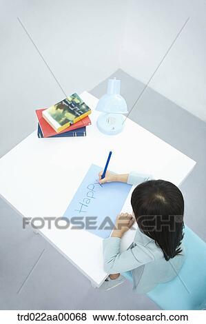 A girl writing 'Happy' on the blue paper with a blue colored pencil View Large Photo Image Stock Photo - A girl writing 'Happy' on the blue paper with a blue colored pencil. Fotosearch