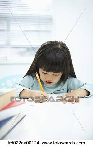 Picture - A girl writing on a notebook with a pencil . Fotosearch