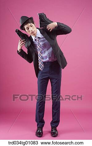Stock Image - A man having the black sneakers on his shoulders. Fotosearch