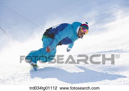 Stock Image - A man snowboarding on the slope. Fotosearch