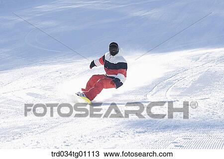 Stock Image - A man snowboarding on the slope. Fotosearch