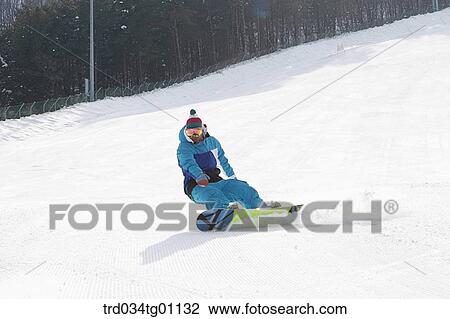 Stock Image - A man snowboarding on the slope. Fotosearch