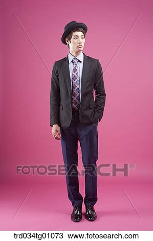 Stock Image - A man wearing black hat and suit with his hand in his pocket . Fotosearch