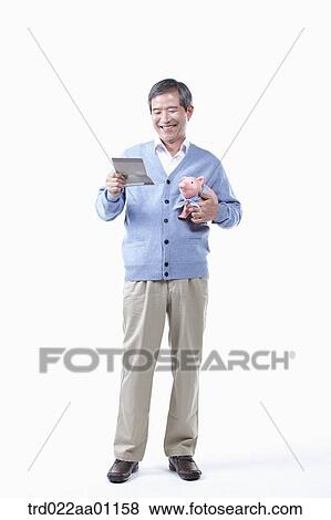 A smiling elderly man looking at the bankbook with a piggy bank View Large Photo Image Stock Photo - A smiling elderly man looking at the bankbook with a piggy bank. Fotosearch