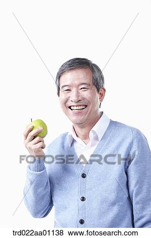 A smiling elderly man with an apple View Large Photo Image Stock Photo - A smiling elderly man with an apple . Fotosearch