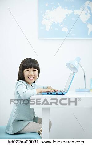 A smiling girl having her hands on keyboard of a laptop in front of the desk View Large Photo Image Stock Image - A smiling girl having her hands on keyboard of a laptop in front of the desk. Fotosearch