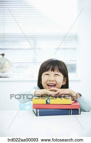 A smiling girl having her hands on the pile of books View Large Photo Image Stock Image - A smiling girl having her hands on the pile of books. Fotosearch