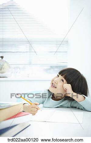 A smiling girl while holding a pencil over a note book View Large Photo Image Stock Image - A smiling girl while holding a pencil over a note book. Fotosearch