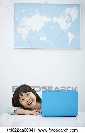 A smiling girl with a laptop on the desk View Large Photo Image Stock Image - A smiling girl with a laptop on the desk. Fotosearch
