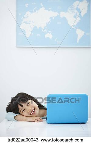 A smiling girl with a laptop on the desk View Large Photo Image Stock Image - A smiling girl with a laptop on the desk. Fotosearch