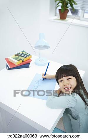 A smiling girl writing 'Happy' on the blue paper with a blue colored pencil View Large Photo Image Stock Image - A smiling girl writing 'Happy' on the blue paper with a blue colored pencil. Fotosearch
