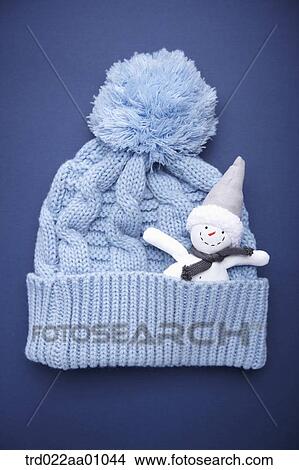 Picture - A snowman in a blue knit hat . Fotosearch