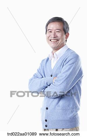 A standing elderly man with his arms folded View Large Photo Image Stock Photo - A standing elderly man with his arms folded. Fotosearch