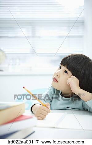 A thinking girl while holding a pencil over a note book View Large Photo Image Stock Photo - A thinking girl while holding a pencil over a note book. Fotosearch