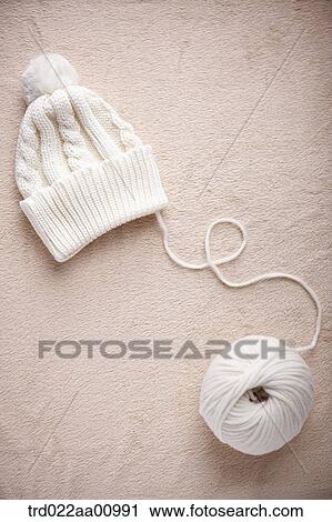 A white knit hat and a ball of white wool View Large Photo Image Stock Image - A white knit hat and a ball of white wool. Fotosearch