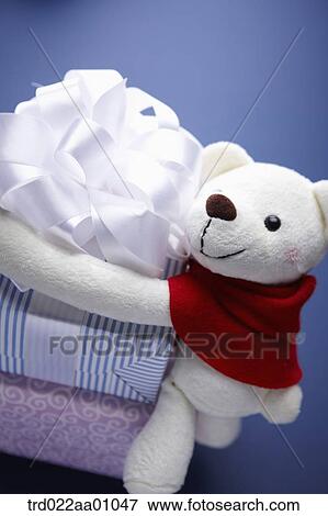 A white teddy bear putting arms around the gift boxes View Large Photo Image Stock Photo - A white teddy bear putting arms around the gift boxes. Fotosearch