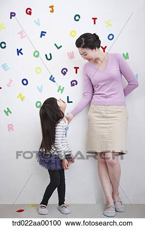 A woman and girl facing each other with alphabet blocks on the wall View Large Photo Image Stock Image - A woman and girl facing each other with alphabet blocks on the wall. Fotosearch