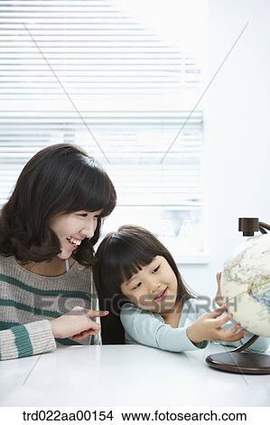 A woman and girl looking at a globe View Large Photo Image Picture - A woman and girl looking at a globe. Fotosearch
