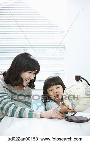 A woman and girl looking at a globe View Large Photo Image Stock Image - A woman and girl looking at a globe. Fotosearch