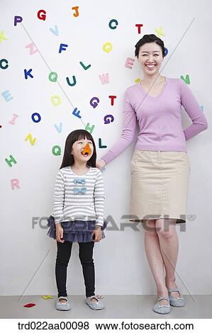 A woman and girl with alphabet blocks on the wall View Large Photo Image Stock Photo - A woman and girl with alphabet blocks on the wall. Fotosearch