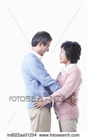 Picture - An elderly man and woman having arms around each other. Fotosearch