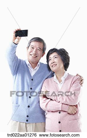 An elderly man and woman photographing together View Large Photo Image Stock Photograph - An elderly man and woman photographing together. Fotosearch