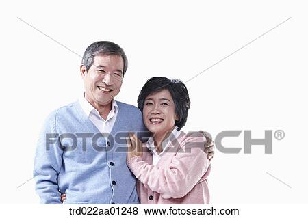 Stock Photo - An elderly man and woman putting arms around on each other . Fotosearch