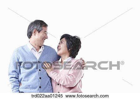 Stock Photography - An elderly man and woman smiling at each other . Fotosearch