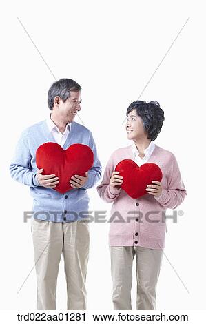 Stock Image - An elderly man and woman with the red heart. Fotosearch