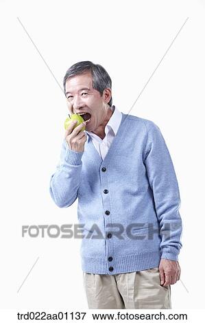 An elderly man biting an apple View Large Photo Image Stock Photo - An elderly man biting an apple . Fotosearch