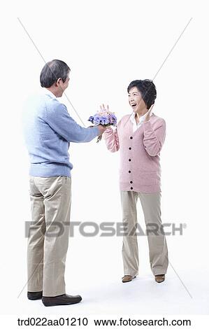 An elderly man giving a bouquet of flower for an elderly woman View Large Photo Image Stock Image - An elderly man giving a bouquet of flower for an elderly woman . Fotosearch