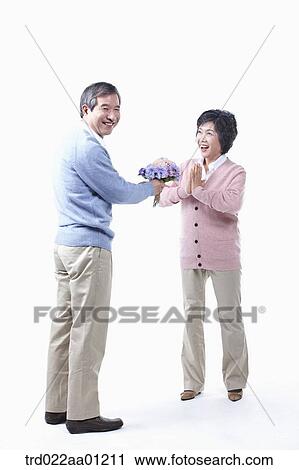 An elderly man giving a bouquet of flower for an elderly woman View Large Photo Image Stock Image - An elderly man giving a bouquet of flower for an elderly woman . Fotosearch