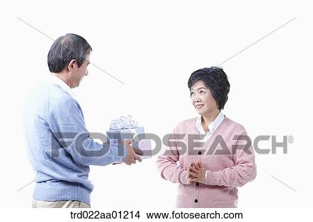 An elderly man giving the gift for an elderly woman View Large Photo Image Picture - An elderly man giving the gift for an elderly woman . Fotosearch