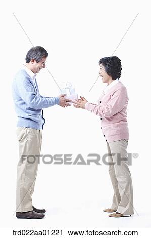 An elderly man giving the gift for an elderly woman View Large Photo Image Stock Image - An elderly man giving the gift for an elderly woman . Fotosearch