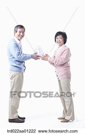 An elderly man giving the gift for an elderly woman View Large Photo Image Stock Image - An elderly man giving the gift for an elderly woman . Fotosearch