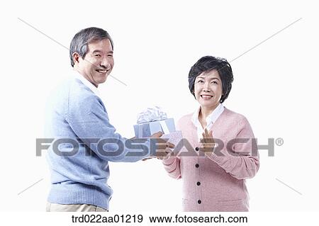 An elderly man giving the gift for an elderly woman View Large Photo Image Stock Photo - An elderly man giving the gift for an elderly woman . Fotosearch