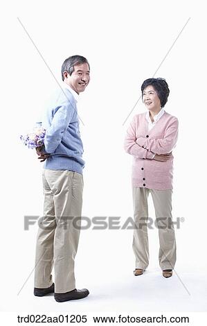 An elderly man hiding a bouquet of flower for an elderly woman View Large Photo Image Stock Photography - An elderly man hiding a bouquet of flower for an elderly woman . Fotosearch