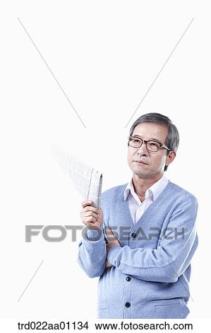 An elderly man holding a newspaper in glasses View Large Photo Image Picture - An elderly man holding a newspaper in glasses. Fotosearch