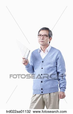 An elderly man holding a newspaper in glasses View Large Photo Image Stock Image - An elderly man holding a newspaper in glasses. Fotosearch