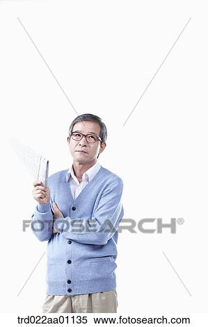 An elderly man holding a newspaper in glasses View Large Photo Image Stock Photography - An elderly man holding a newspaper in glasses. Fotosearch