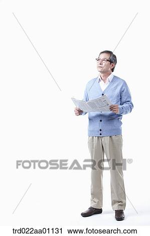 Stock Image - An elderly man looking at the sky with a newspaper in glasses. Fotosearch
