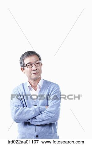 Stock Photo - An elderly man wearing glasses with his arms folded. Fotosearch