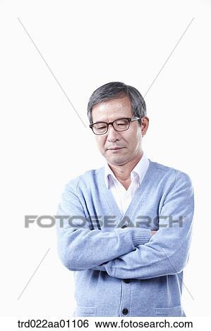 Stock Photograph - An elderly man wearing glasses with his arms folded. Fotosearch