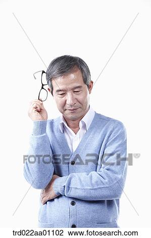 Stock Image - An elderly man with the glasses on his head . Fotosearch