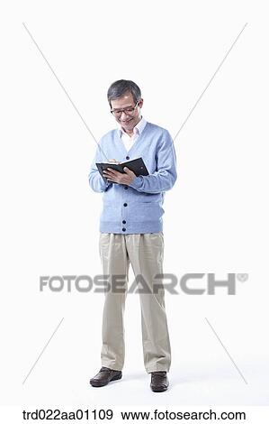 An elderly man writing on a planner in glasses View Large Photo Image Stock Photo - An elderly man writing on a planner in glasses. Fotosearch