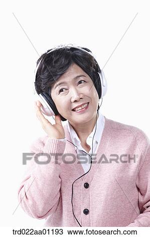 An elderly woman listening to the music with a headset on View Large Photo Image Stock Image - An elderly woman listening to the music with a headset on. Fotosearch