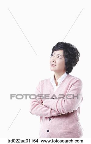 An elderly woman looking at the sky with her arms folded View Large Photo Image Picture - An elderly woman looking at the sky with her arms folded. Fotosearch
